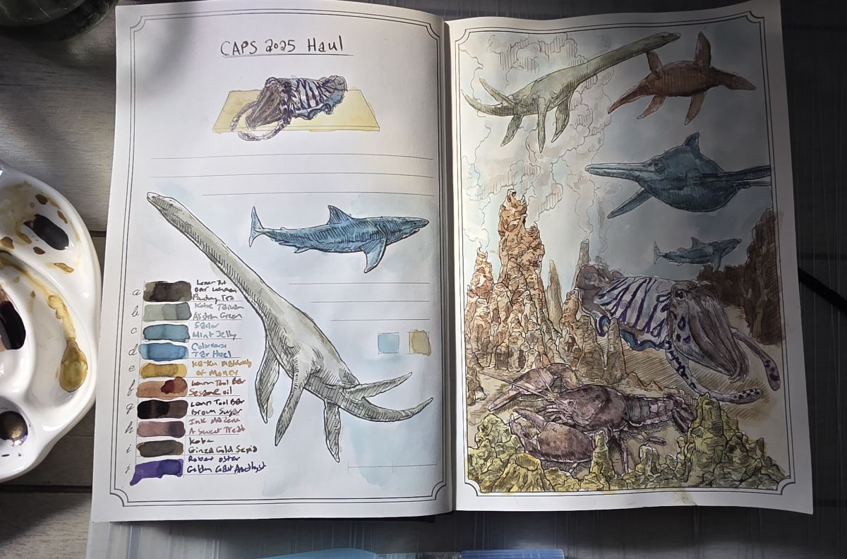 Dominant Industry Ink Archiving Book A Log of Atlantis open to a page spread with sea creatures painted in with 10 different fountain pen inks from CAPS 2025 Haul, ceramic paint palette to the side with different colors of ink.