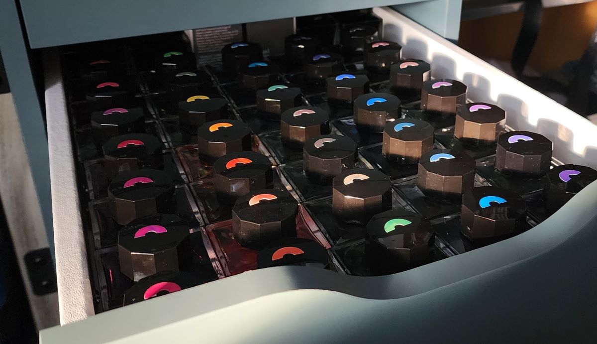 A drawer full of bottles of Sailor Manyo fountain pen ink with color labels on the caps, arranged by color.