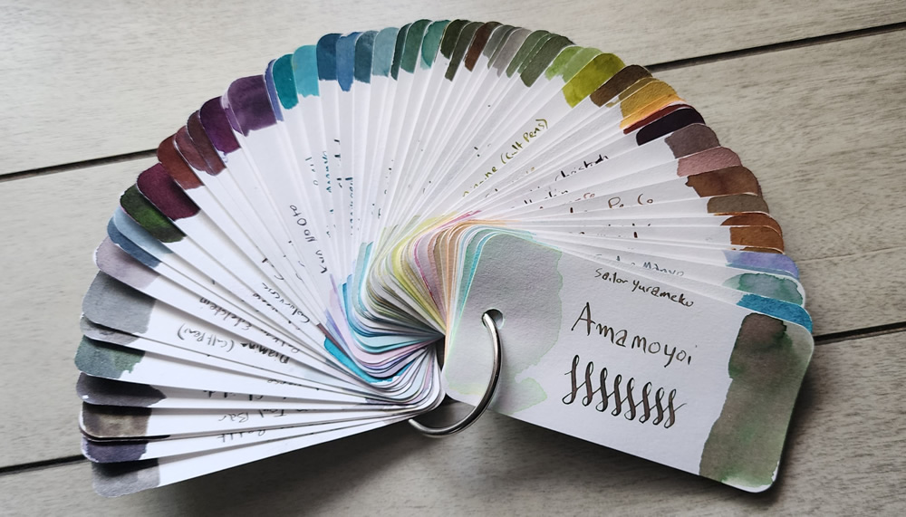 A Col-o-ring fanned out to show a range of earthy browns, greens, blues, purples, and grays, plus several dual-shading inks.