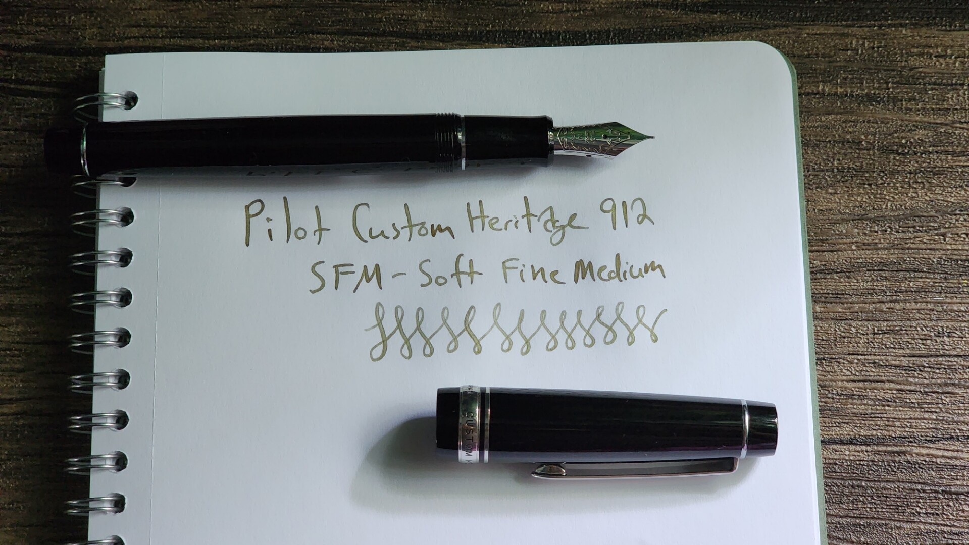 A Pilot Custom Heritage 912 black pen with silver trim, with a Soft Fine Medium (SFM) nib. A short writing sample showing the slight flex.