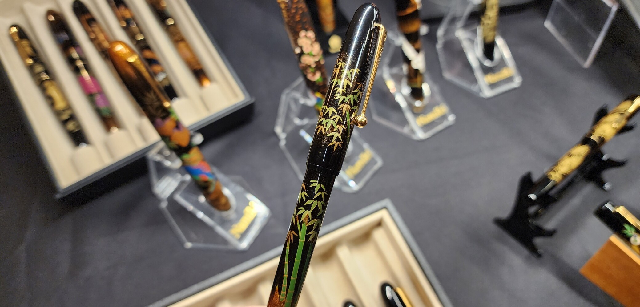 Namiki Yukari pen with Bamboo design and other Namiki Maki-e pens out of focus in the background.