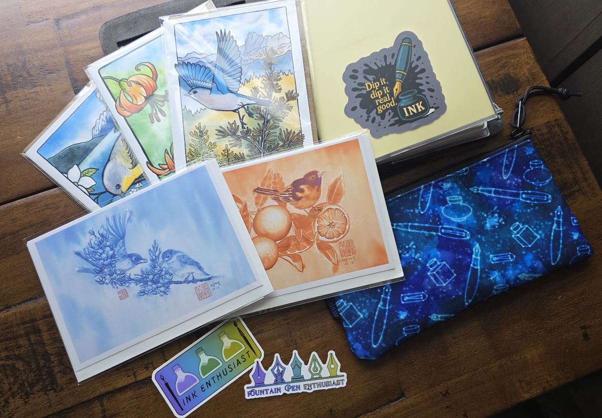 Stickers featuring pens and ink, 5 notecards featuring bird art, and small Rickshaw pouch with stationery constellations design.