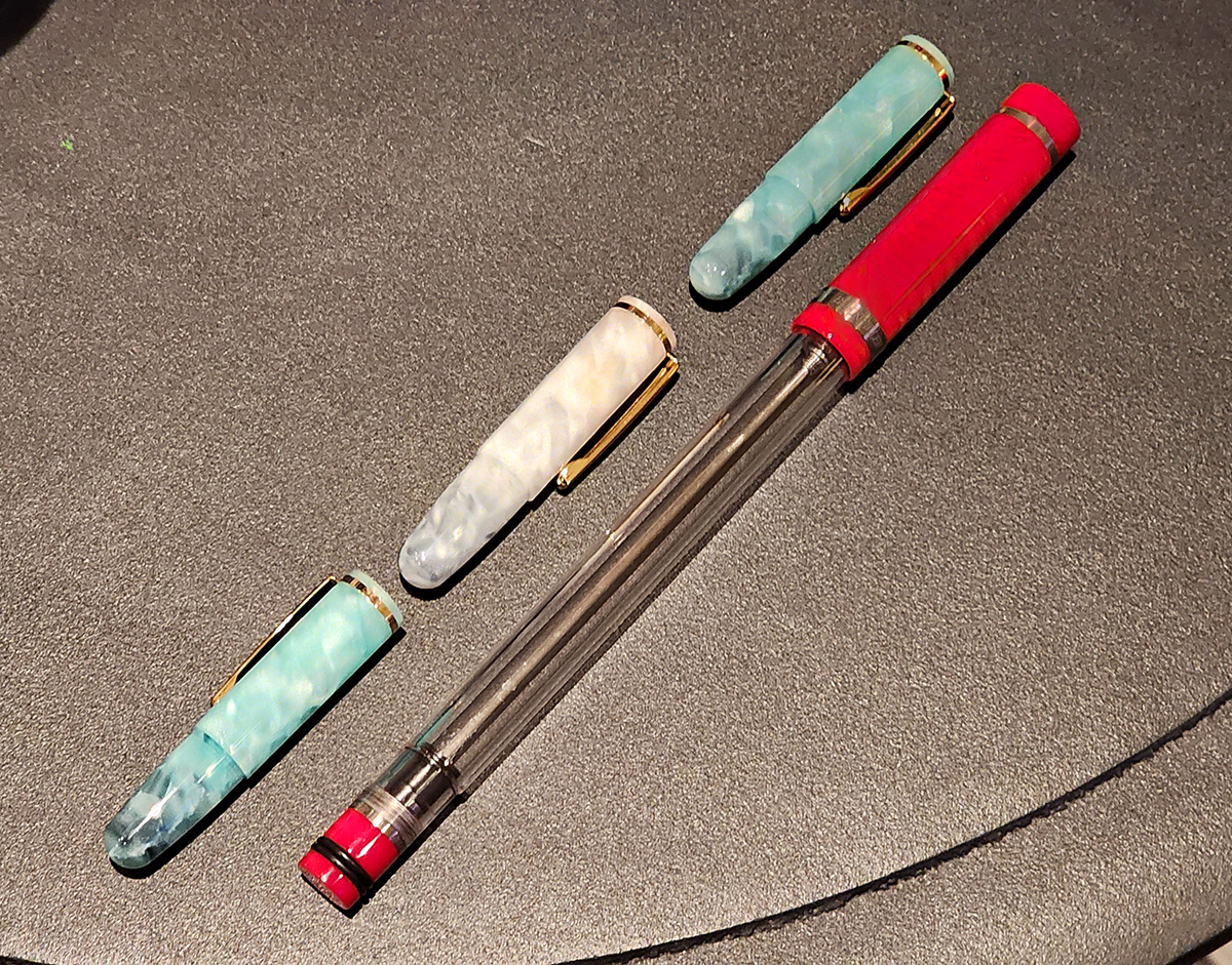 Three small Wancher PuChiCo pens laid end-to-end at about the same length as a quite long Conid Giraffe pen.