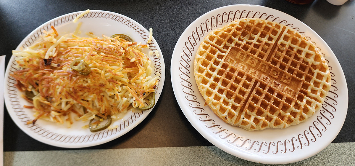 A plate of hash browns with jalapeños and a waffle from Waffle House.