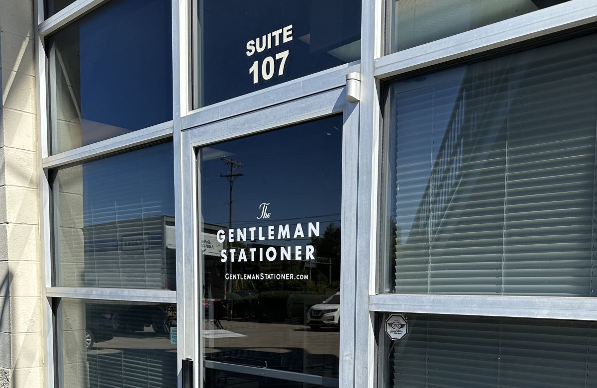 The front door and windows of the showroom for The Gentleman Stationer in Suite 107. 