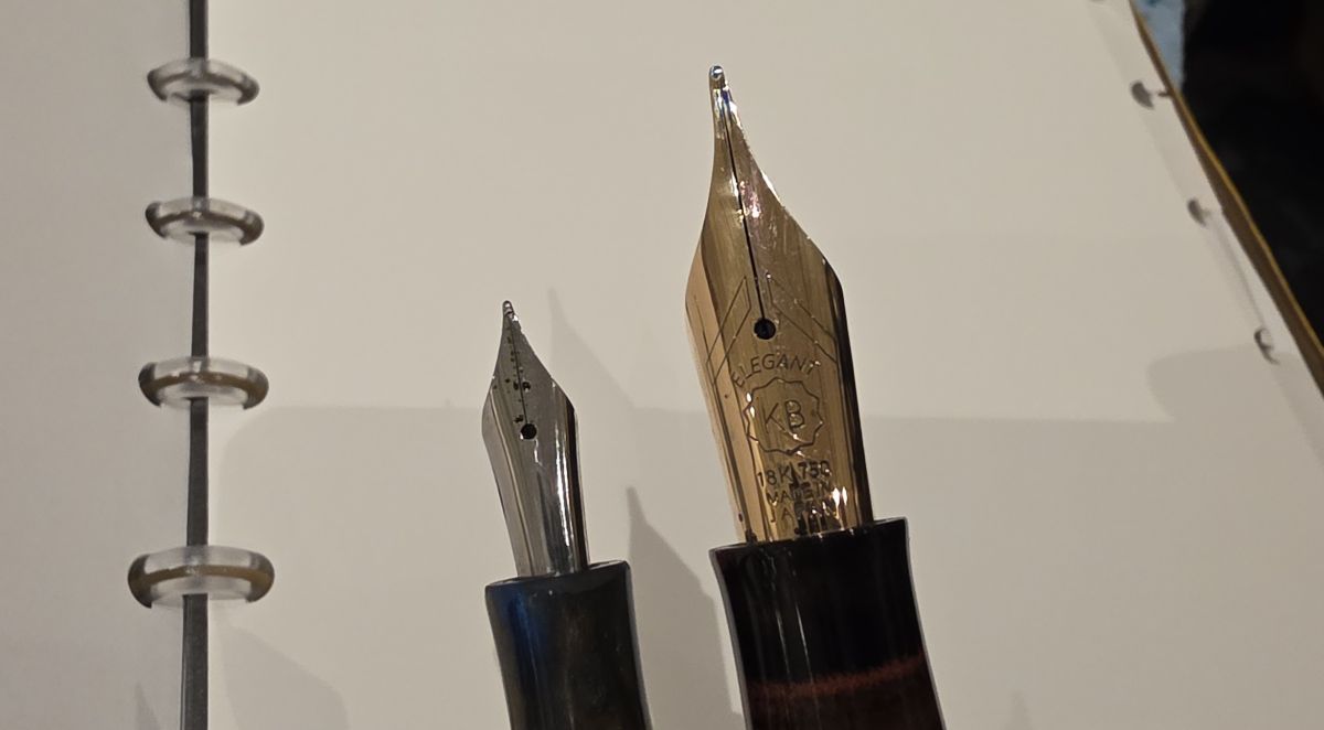 A small number 5 silver color Bock nib next to a giant gold nib.