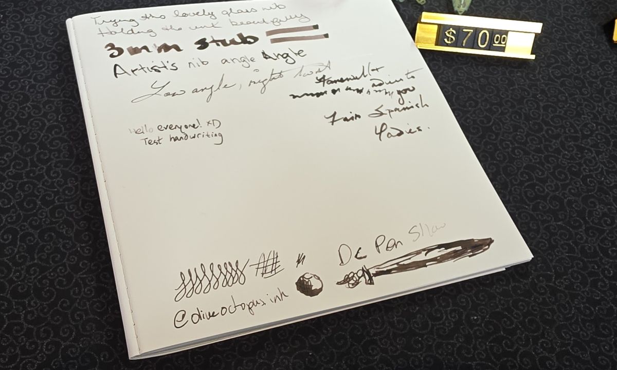 A test paper notebook from the Hanabi Glass table with writing tests and sketches.