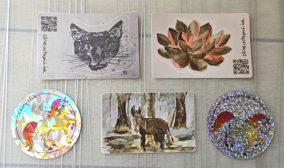Five stickers including two with ink drawings and a QR code and domain for oliveoctopus.ink, two round Ink Pony Club stickers with shiny holographic background, and an ink sketch with a bewildered donkey standing in a swamp.