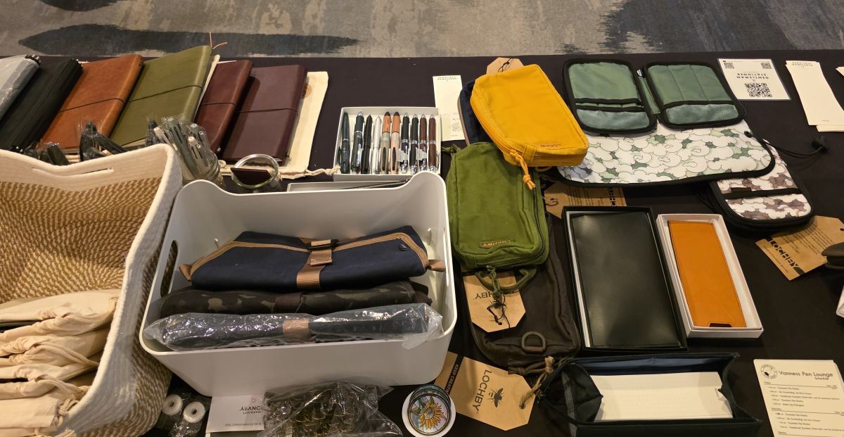 The view from behind The Gentleman Stationer table with leather notebook covers, pouches and other pen storage, pens and multipens, bags, etc.