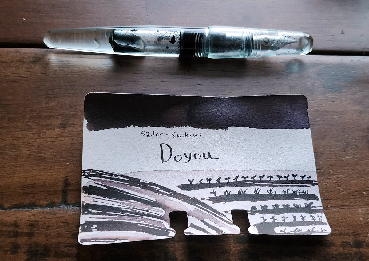 A Col-o-dex card for the dark brownish black Sailor Doyou ink with a swatch and sketch of fertile fields.