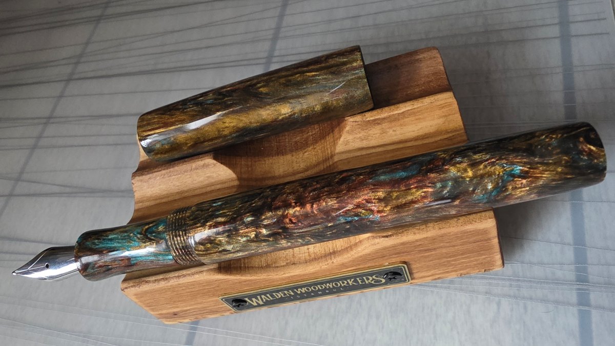 A turned resin fountain pen from Zodiac Pens, Capricorn model, dark brown material with yellow and patina green streaks.