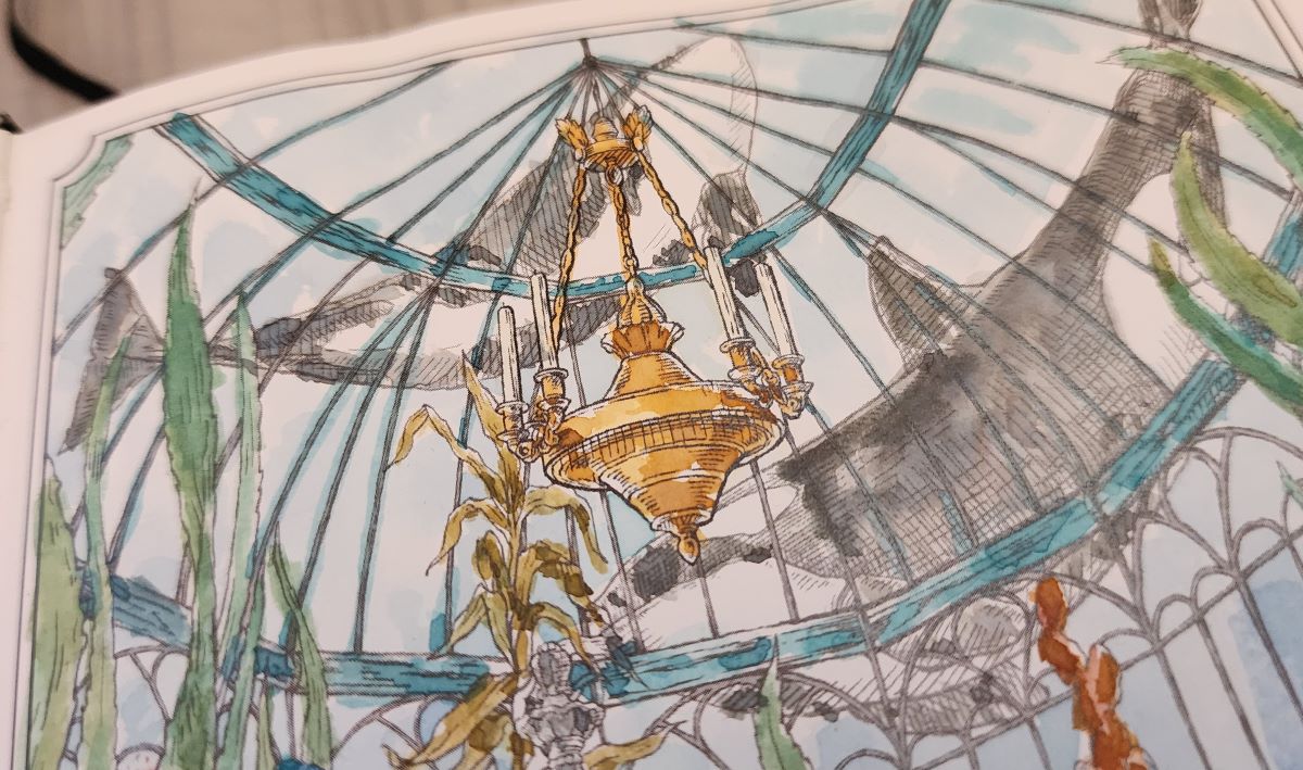 Close up of painted page showing the inside of a glass domed room with a golden chandelier hanging from the center, with tall underwater plants growing inside and large orcas swimming outside the dome.