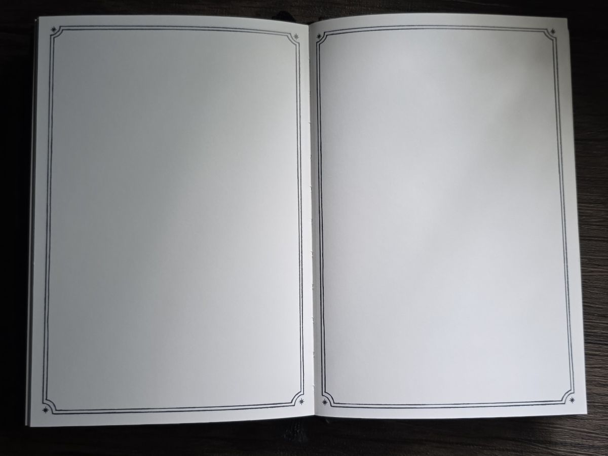 Ink Archiving book open to blank pages with a fancy border around the edge of each page.
