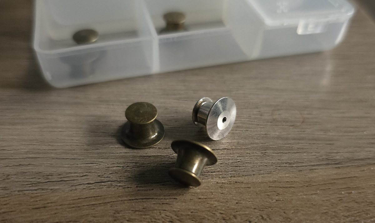 Metal locking pin backs in dark bronze and silver colors.
