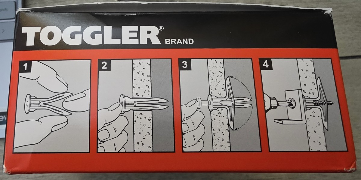 A box of plastic wall anchors from Toggler with illustrated instructions showing how the anchor is installed.