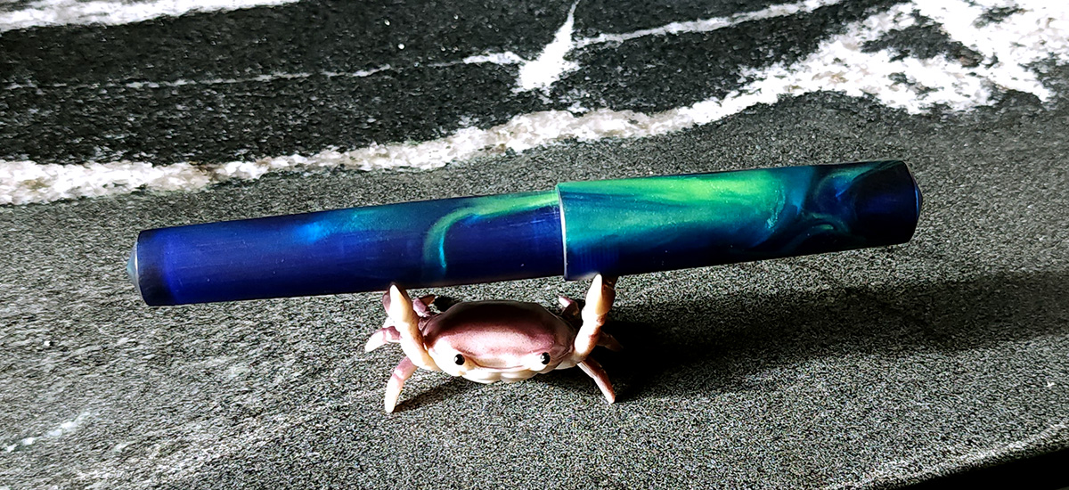 A translucent matte finish resin fountain pen in cobalt blue and pearlescent bright green.