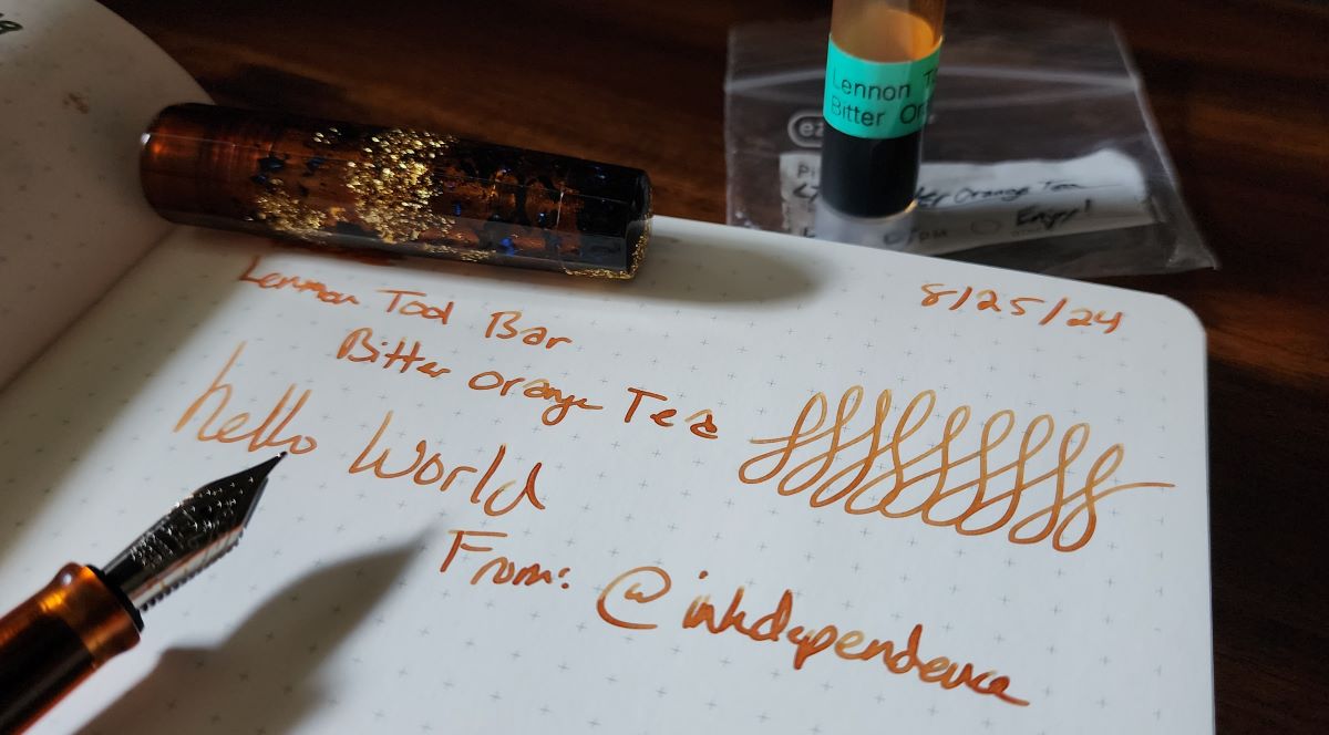 Writing test with a dark orange ink with good shading and a Benu fountain pen in translucent brown resin with gold and blue glitter