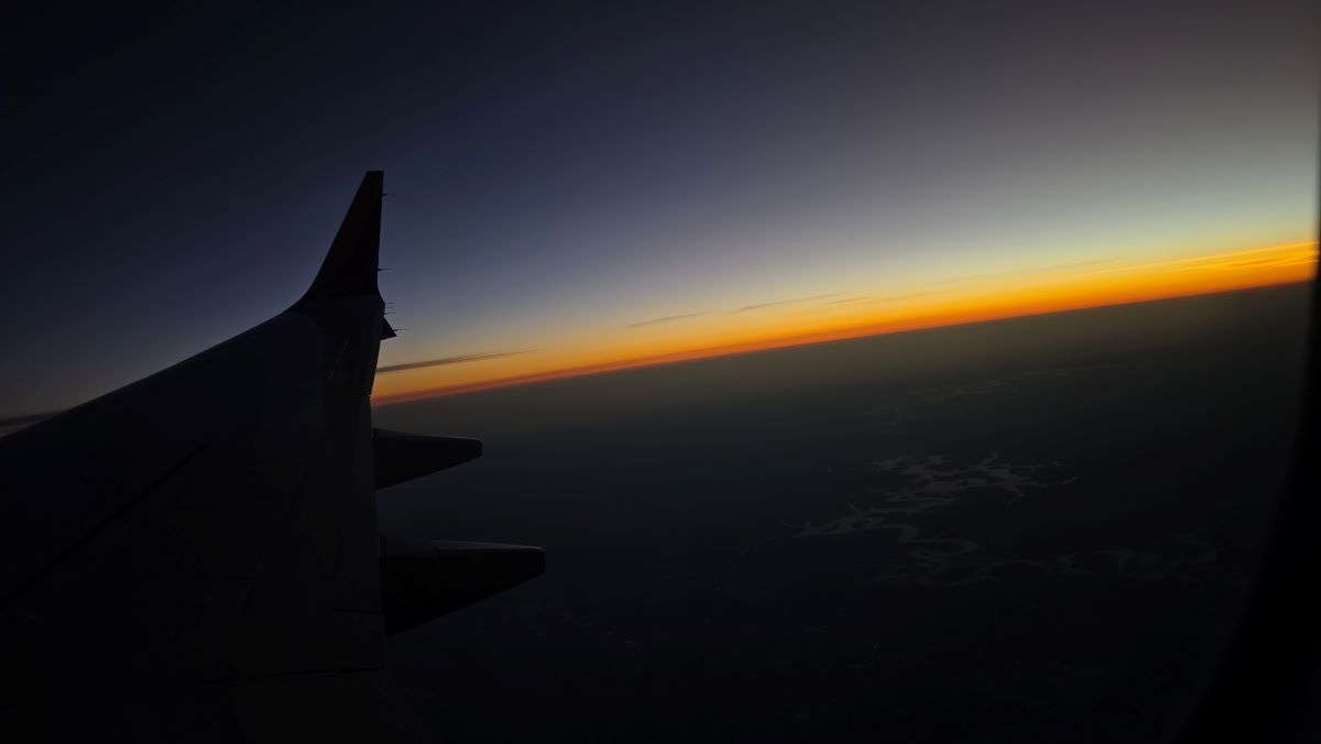 View of thin band of sunrise orange from the window of an airplane.