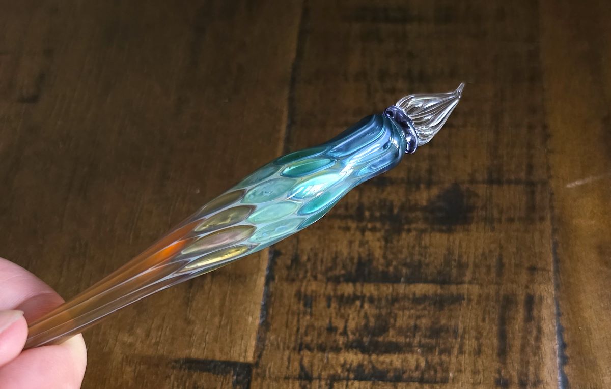 Closeup of multicolor glass pen with angled fude-like tip.