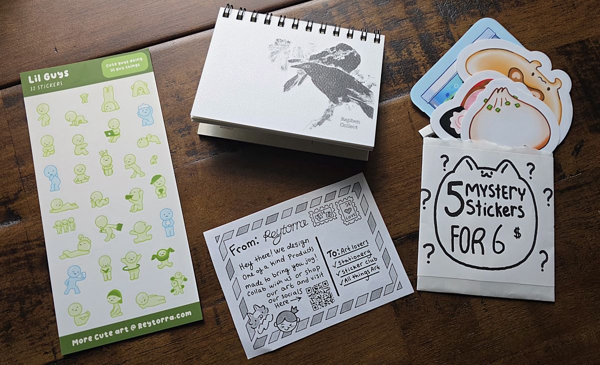 Sheet of small stickers, mystery pack of large stickers, and small spiral bound memo notebook with black birds on the cover all from Reytorra.