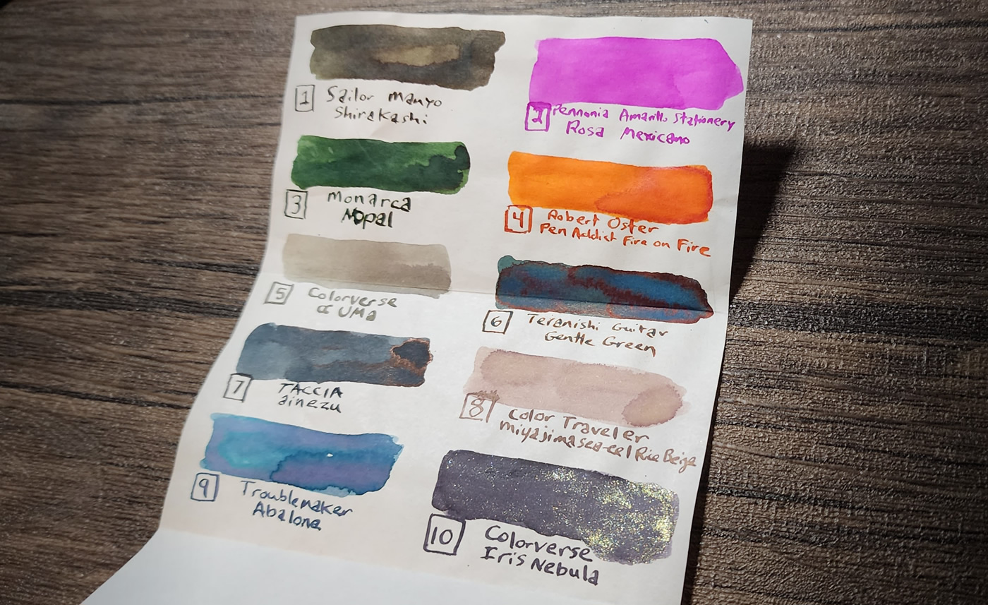 Small piece of paper with 10 ink swatches and ink names in a variety of colors.