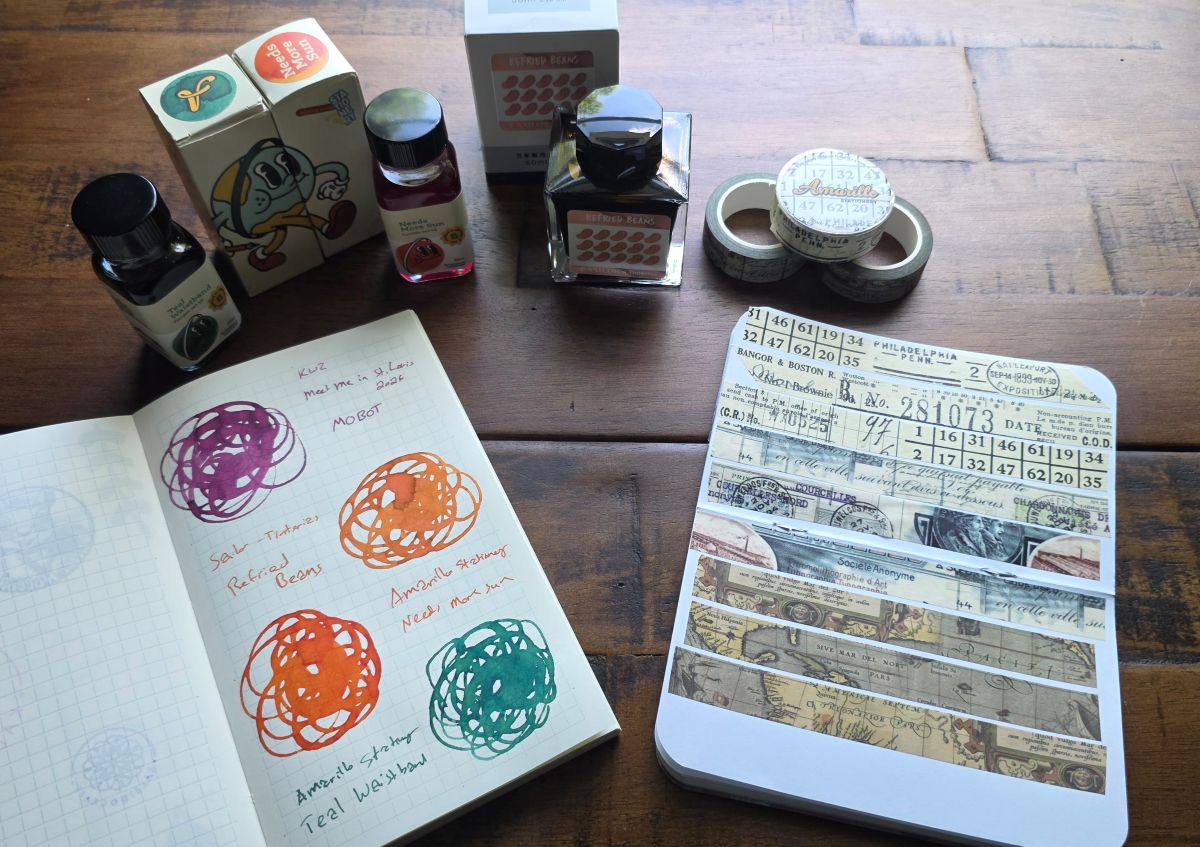 Three bottles of fountain pen ink and corresponding swatches, and three rolls of washi tape next to a notebook showing the patterns of each.