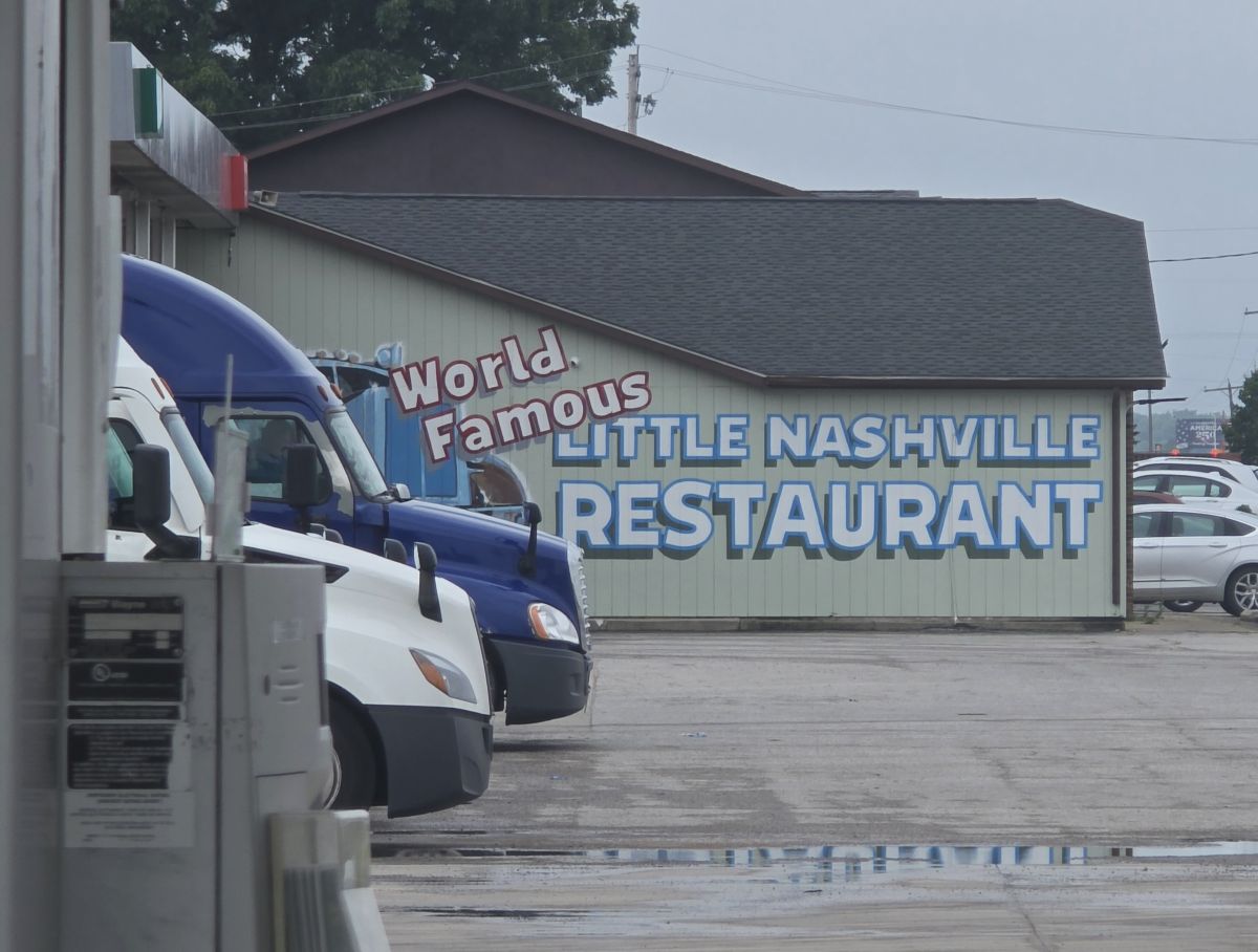 The side of a building at a gas station with the painted text 'World Famous Little Nashville Restaurant'