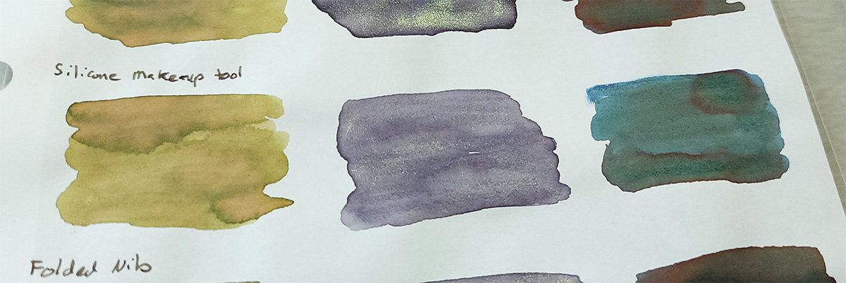 Ink swatches of Sailor 280 with pale green and areas with a more pinkish hue with darker edges, Colorverse Iris Nebula with an even, visible spread of champagne color shimmer, and Taccia Sabimidori with shading blues and greens and edges of red sheen.