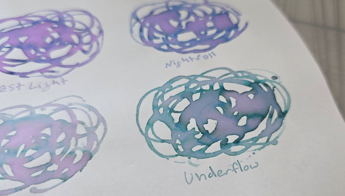 Closeup of an ink swatch with overlapping swirled lines in a rough circle for Van Dieman's Underflow which is a chromashading teal with shades of blue and purple.