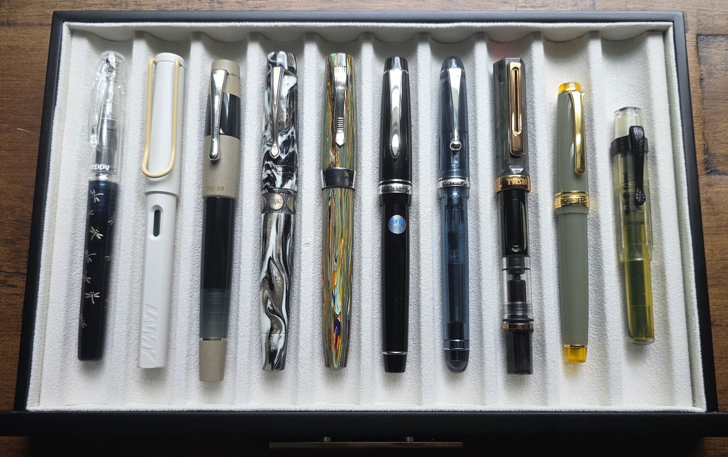 Ten fountain pens in a lined drawer.