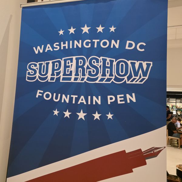 A banner with white text on a blue background and a red fountain pen graphic announcing the Washington DC Fountain Pen Supershow.