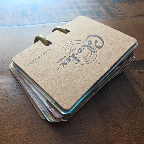 A stack of Col-o-dex fountain pen ink swatch cards with a variety of colors visible along the edges, held together by 1 inch round disks in the card tab slots.