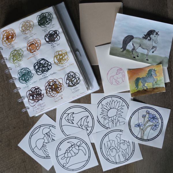 Fountain pen ink swatches, small A6 booklet, Ink Pony Club envelope and painted ponies, small square papers with stained glass sea creature and floral designs including one that's painted with fountain pen ink.
